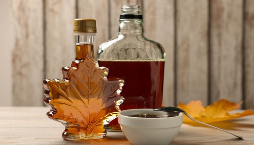 Bottles and bowl of tasty maple syrup